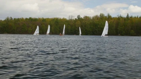 View from boat bow when fast moving over water with regatta in background Stock Footage 75076184