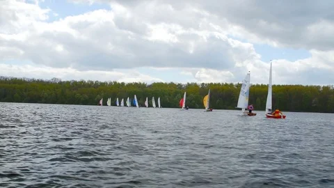 View from boat bow when fast moving over water with regatta in background Stock Footage 75076548