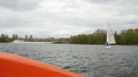 View from boat bow when fast moving over water with regatta in background Stock Footage 75077063