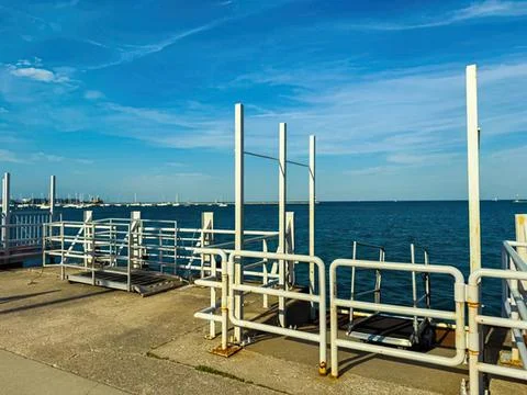 View of boat deck with white railing and blue ocean Stock Photos