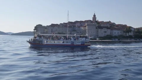 View of boat in Luka Korculanska Bay leaving Korcula Old Town, Korcula, Stock Footage