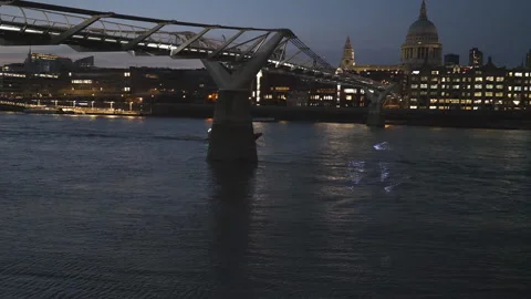 A view of a boat passing beneath a pedestrian bridge at night. Stock Footage 140886206