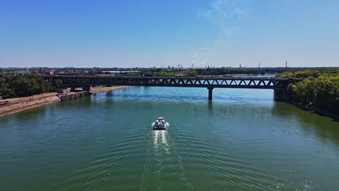 View of a boat passing under a bridge on a sunny day in a river 库存影片 343126030