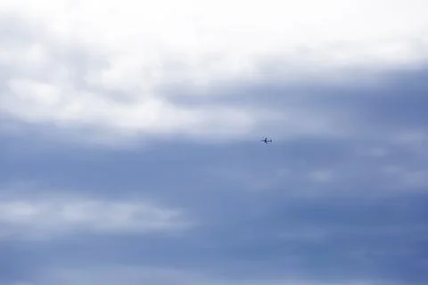 View from the bottom of a passenger plane taking off or landing against a bri 库存照片