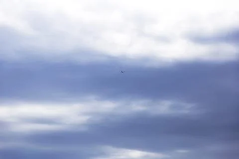 View from the bottom of a passenger plane taking off or landing against a bri Stock Photos