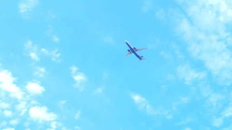 The view from the bottom up. the plane flies in the blue sky with clouds. Stock Footage 128069636