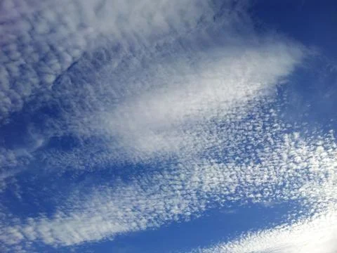 View from bottom on the white clouds on the blue sky background Stock Photos