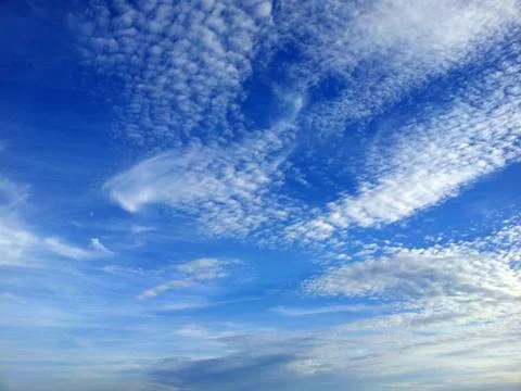 View from bottom on the white clouds on the blue sky background Stock Photos