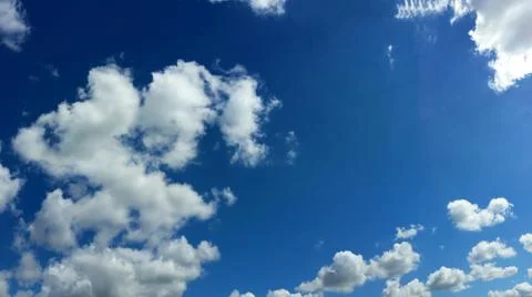 View from bottom on the white clouds on the blue sky background Stock Photos