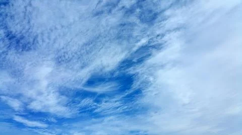 View from bottom on the white clouds on the blue sky background Stock Photos
