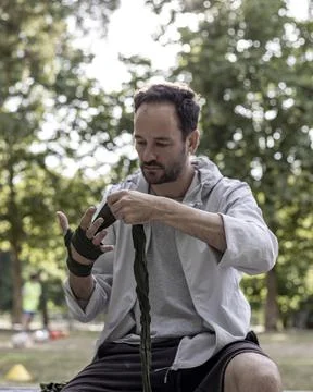 View of a boxing player preparing for the training in a public park, box spor Stock Photos