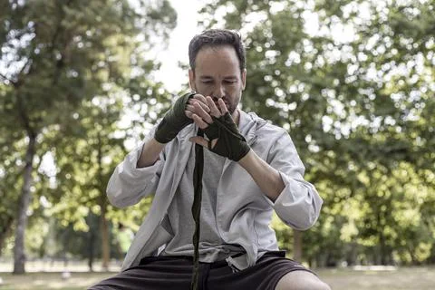 View of a boxing player preparing for the training in a public park, box spor Stock Photos