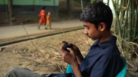 View of a boy using a smartphone in Bogura, Bangladesh. Video stock 335025291
