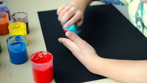 View of boy's hands holding sponge with paint on it and using it, steadycam shot Stock-Footage 73950504