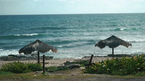 View of the breaking waves and tropical umbrellas in Isla Mujeres, Mexico. Stock Footage 169979624