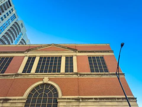 View of a brick building with windows under a clear blue sky. A street light  Stock Photos
