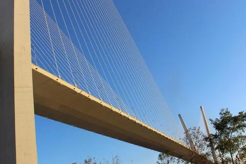 View of the bridge against the blue sky. The cables and high pylons of this long Stock Photos