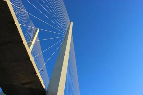 View of the bridge against the blue sky. The cables and high pylons of this long Stock Photos