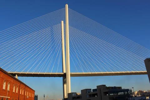 View of the bridge against the blue sky. The cables and high pylons of this long Stock Photos