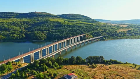 View of a bridge crossing a river with hills in the background during early Stock Footage 342335398