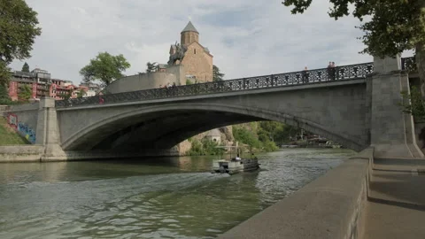 View of bridge over Kura River and Metekhi Temple on cliff Stock Footage 292306082