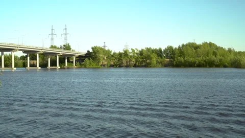 View of the bridge over the river. Blue river on a background of green trees. A Stock-Footage 132287891