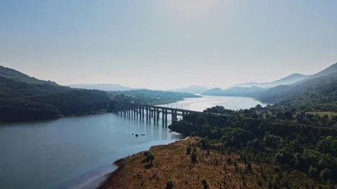 View of a bridge over a river surrounded by hills and trees Stock Footage 340381947