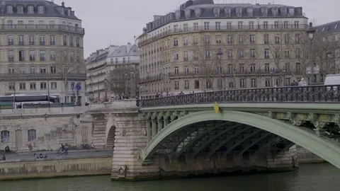 A view of a bridge over the Seine River in Paris with buildings and tourists Stock Footage 305757308
