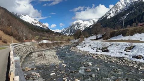 View from a bridge over a thawing river coming from the Swiss alps in the Stock-Footage 306142700