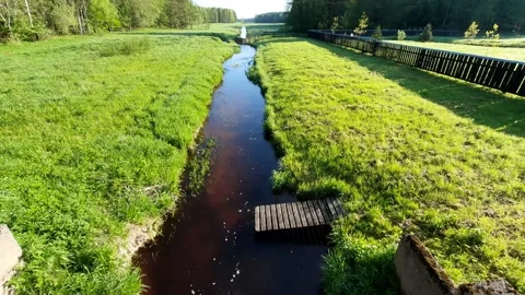 View from the bridge to the water. Water flows slowly in the channel. Stock Footage 154895629