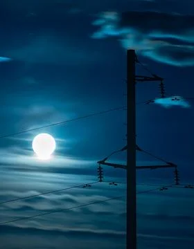 View of the bright circle of the moon on a full moon in a cloudy night sky Stock Photos