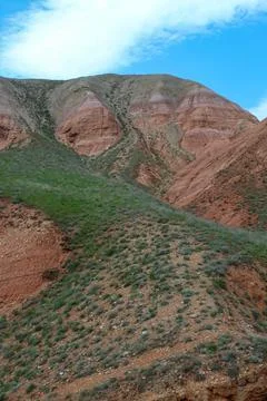 View of the bright red sandy-clayey slopes of the mountain Big Bogdo Stock Photos