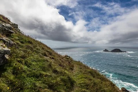 A view of The Brisons off the Cornish coast, with clouds rolling in off the.. Foto stock