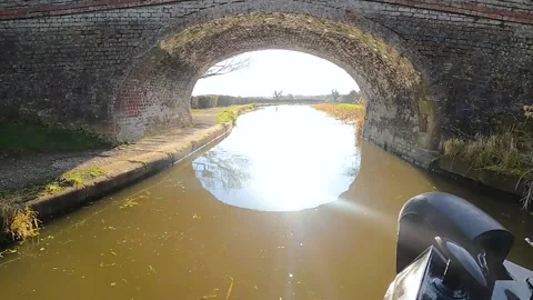 View of a British canal in rural setting with stone bridge Stock Footage 194720440