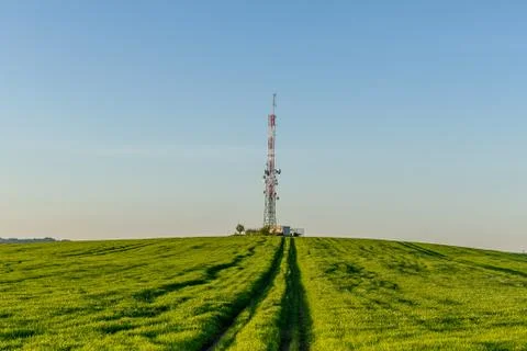 View of a broadcasting tower lying on a hill in the middle of a landscape in  Photos