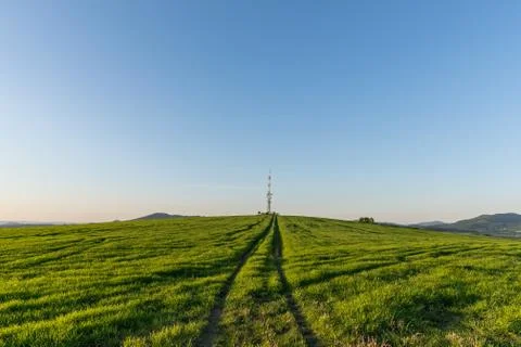 View of a broadcasting tower lying on a hill in the middle of a landscape in  Фото