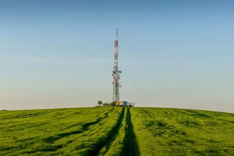 View of a broadcasting tower lying on a hill in the middle of a landscape in  Stock-Fotos