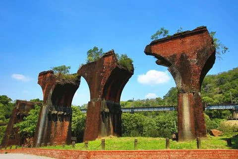 View of broken bridge with train track and green trees Stock Photos