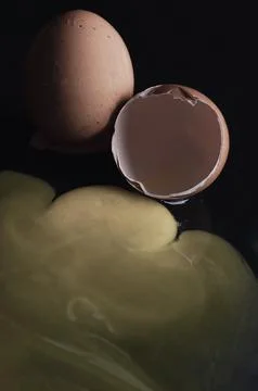View of Broken egg yolk with Broken raw chicken eggshell in front of Fresh .. Stock Photos