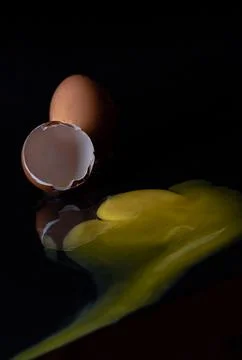 View of Broken egg yolk with Broken raw chicken eggshell in front of Fresh .. Stock Photos