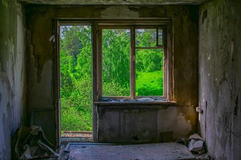 View of a broken window of an abandoned building from inside a dirty dusty room Stock Photos