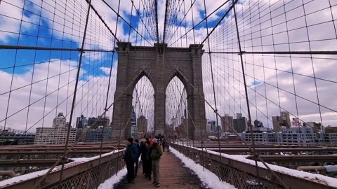 View of the Brooklyn Bridge's iconic arches and cables, with pedestrians and Stock Footage 301486914