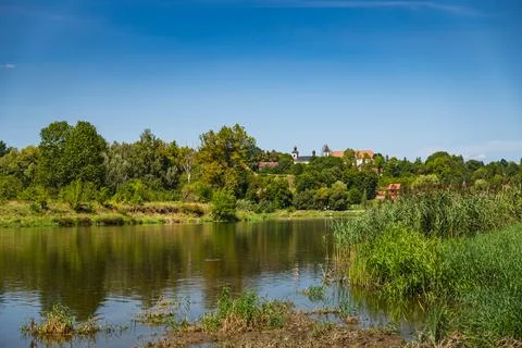 A view of the Bug River with its banks reflected in the water during the summ Stock Photos