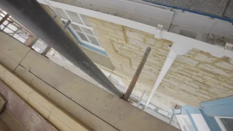 A view of a building with a pipe sticking out of it Stock Footage 302441953