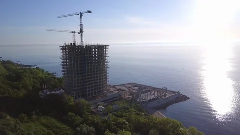 View of building a skyscraper background sea and sky sunset drone footage Video stock 86228983