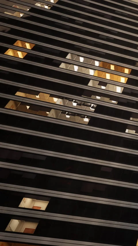 View of a building through horizontal metal bars in a city at night Vídeos de archivo 338352518