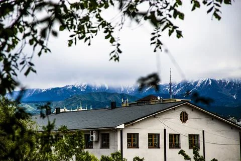 View of the building through the trees. Mountains on the background Foto stock