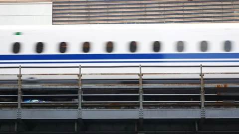 View to bullet high speed train on railway track while moving fast through .. Stock Footage 256857011