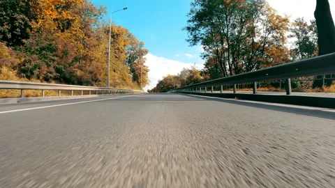 View from the bumper of a car driving on an asphalt road at high speed in slow Vídeos de archivo 224875433