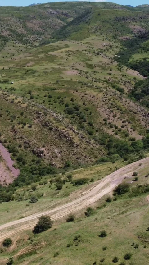 View of bumpy dirt road winding through rolling steppe hills in Kazakhstan Видео 338127877